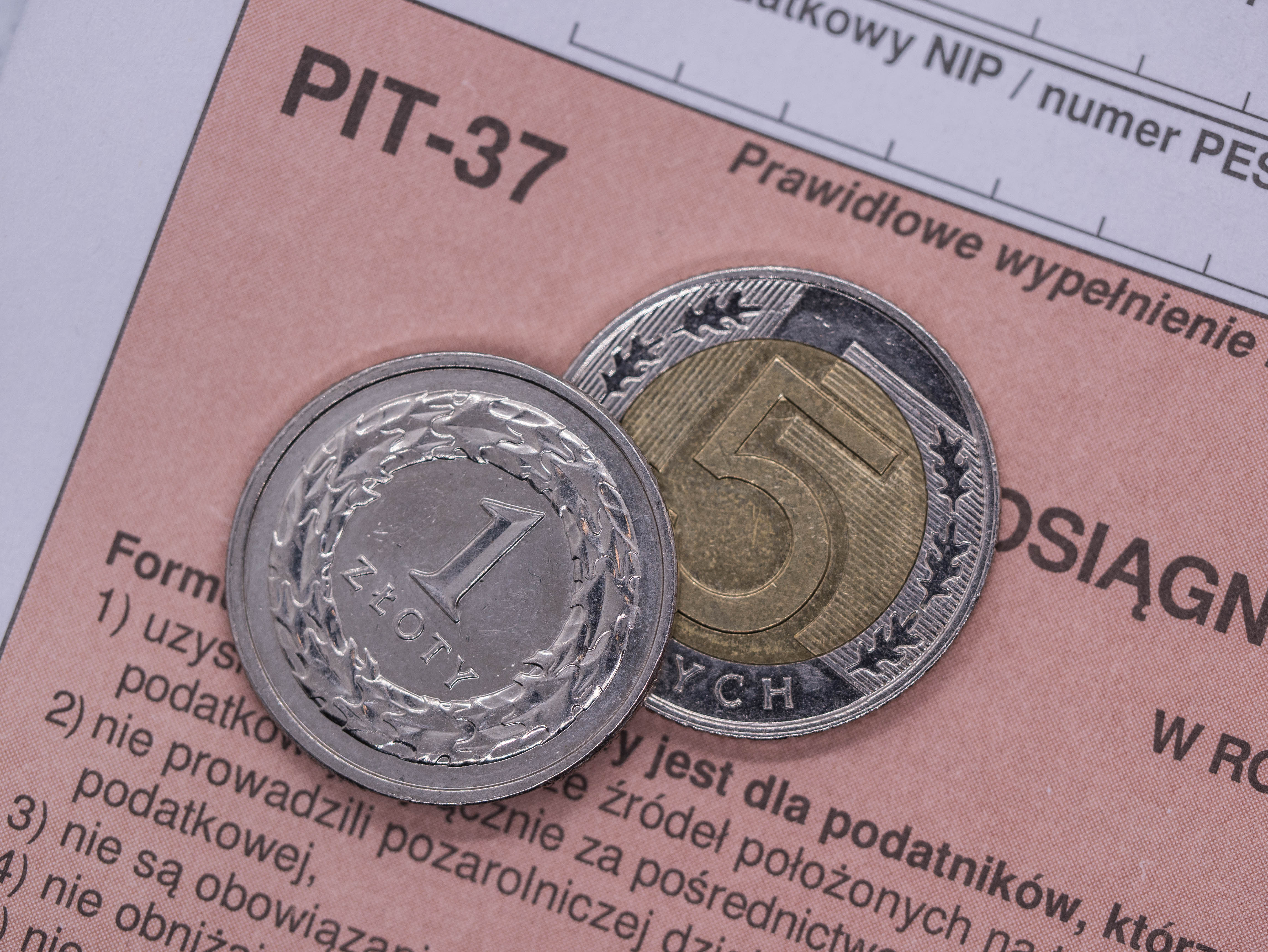 formularz zeznania podatkowego PIT-37 na którym leżą monety 1-złotowy i 5-złotowy