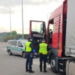 na drodze, dwóch funkcjonariuszy Służby Celno-Skarbowej stoją przy samochodzie ciężarowym.