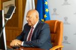 Fotografia przedstawia siedzącego za biurkiem ministra Tadeusza Kościńskiego.