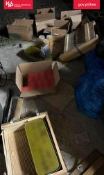 Pootwierane pudełka leżą bez ładu na podłodze, część z nich zawiera opakowania z nabojami.