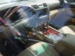 Fotografia wykonana zza szyby bocznej przedstawia wnętrze samochodu marki Lexus - deskę rozdzielczą.